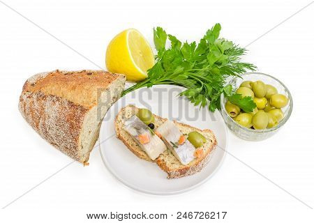 Open Sandwich Made Of Brown Sprouted Bread, Slices Of Fillet Of Pickled Atlantic Herring And Green O