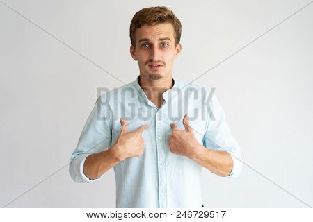 Surprised And Doubted Guy In White Casual Shirt Asking Who, Me. Handsome Young Caucasian Man With Up