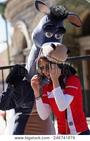 ST. PETERSBURG, RUSSIA - JUNE 20, 2018: Serbian football fan makes photo with a street animator at FIFA Fan Fest during FIFA World Cup Russia 2018. The city host 7 matches of FIFA World Cup