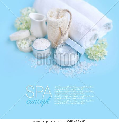 Spa Composition With Cream, Salt, Towel And Flowers On A Blue Background.