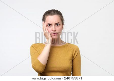 Young European Woman In Yellow Sweater Feeling Tooth Pain. Yeenager Holding Her Hand Near Cheek. Pro