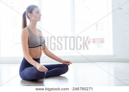 Photo Of A Young, Beautiful Woman, Doing Yoga And The Lotus Posity In The Studio, Beautiful And Heal