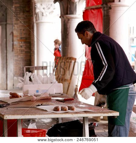 Venice, Italy - May 08, 2010: Man Cleans The Fish At The Venice Market