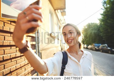 Portrait Of Happy Smiling Woman Walking On The Street. Wman Making Selfie By Phone Camera On The Str