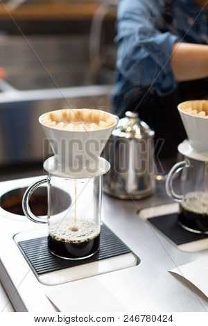 The Proccess Of Hand Dripping Coffee In The Coffee Shop. Barista On The Background.