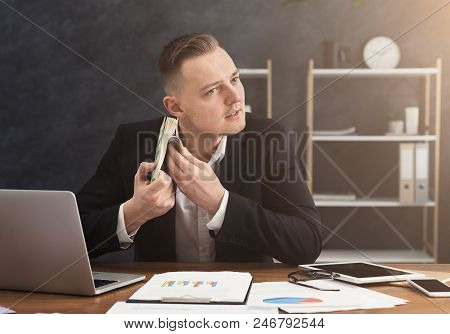 Businessman Holding Stack Of Money And Listening To Its Sound. Counding Bills On Hear, Profit Or Bon