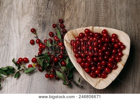 Fresh Red Cherries In A Wooden Plate On A Wooden Table. Wooden Plate On A Wooden Background. Next To