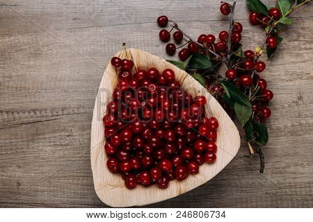 Fresh Red Cherries In A Wooden Plate On A Wooden Table. Wooden Plate On A Wooden Background. Next To