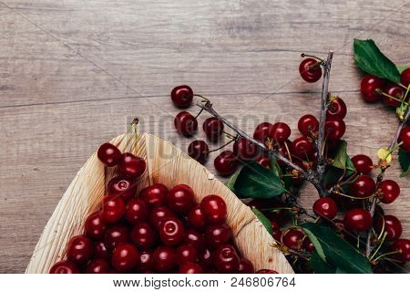 Fresh Red Cherries In A Wooden Plate On A Wooden Table. Wooden Plate On A Wooden Background. Next To