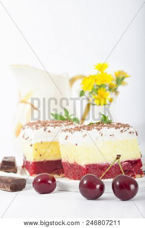 Sweet Homemade Cherry Cake With Vanilla And Whipping Cream On White Plate. Small Vase With Wild Flow