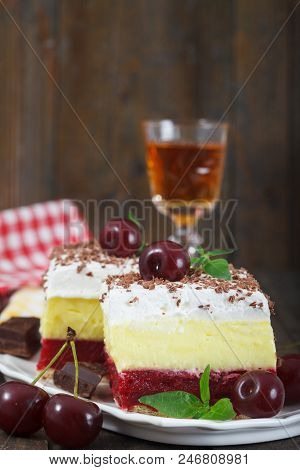 Homemade Cherry Cake With Vanilla And Whipping Cream On Wooden Table. Glass Of And Cherry Brandy In 