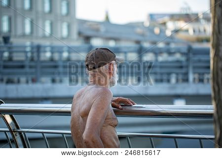 Fine Art Photo Portrait Of Elderly Man With Wrinkled Closeup Face. Sunburnt Homeless Man In A Cap Ou