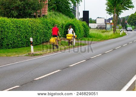 Postman Riding His Cargo Bike Carrying Out Mail In Neighborhood