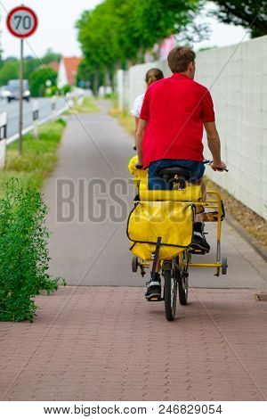 Postman Riding His Cargo Bike Carrying Out Mail In Neighborhood