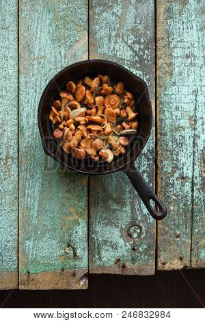 Wild Edible Mushrooms. Chanterelle Mushrooms Fried In Cast Iron Pan With Onin On Shabby Blue Backgro