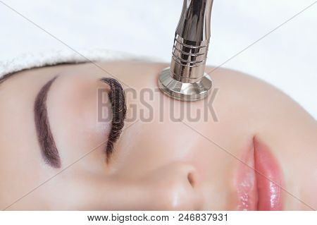 The Cosmetologist Makes The Procedure Microdermabrasion Of The Facial Skin Of A Beautiful, Young Wom