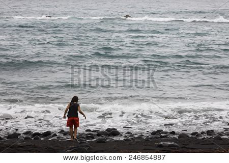A Child Plays Solitary In Front Of The Sea