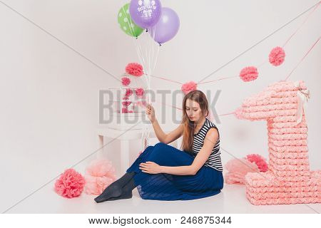 The Blonde Woman With The Colored Balls On A White Background. Studio Portrait Of An Attractive Girl