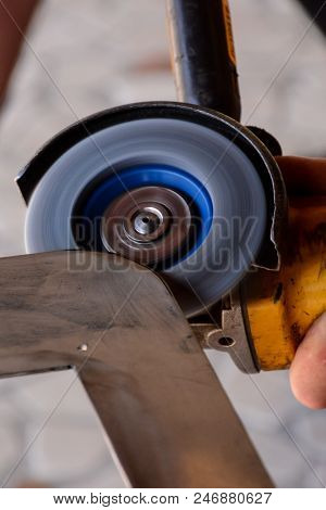Heavy Industry Worker Cutting Steel With Angle Grinder At Car Service