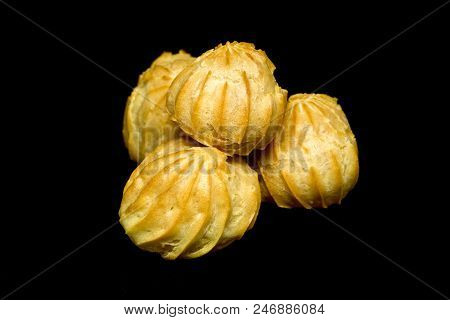 Heap Of Three Profiteroles Isolated On The Black Background.