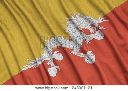 Bhutan Flag  Is Depicted On A Sports Cloth Fabric With Many Folds. Sport Team Waving Banner