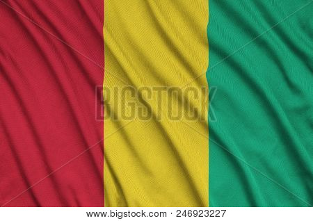 Guinea Flag  Is Depicted On A Sports Cloth Fabric With Many Folds. Sport Team Waving Banner