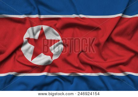 North Korea Flag  Is Depicted On A Sports Cloth Fabric With Many Folds. Sport Team Waving Banner