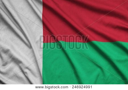 Madagascar Flag  Is Depicted On A Sports Cloth Fabric With Many Folds. Sport Team Waving Banner