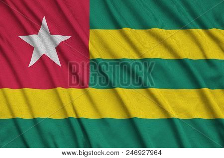 Togo Flag  Is Depicted On A Sports Cloth Fabric With Many Folds. Sport Team Waving Banner
