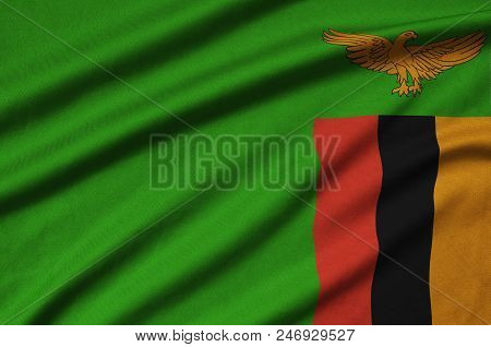 Zambia Flag  Is Depicted On A Sports Cloth Fabric With Many Folds. Sport Team Waving Banner