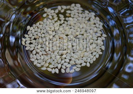 Seeds Of Sesame Kernels In A Glass Transparent Black Plate.