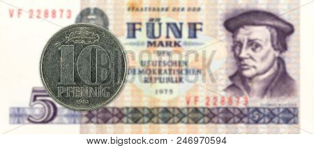 10 Pfennig Coin Against Historic 5 East German Mark Bank Note