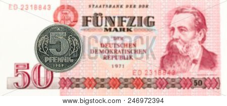 5 Pfennig Coin Against Historic 50 East German Mark Bank Note
