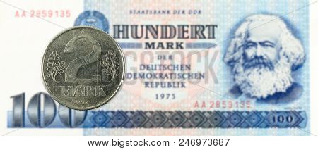 2 Mark Coin Against Historic 100 East German Mark Bank Note