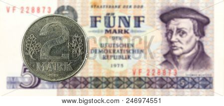 2 Mark Coin Against Historic 5 East German Mark Bank Note