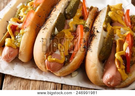 Chicago Style Hot Dog With Mustard, Tomatoes, Pickled Cucumbers, Onions And Sauce Close-up. Horizont