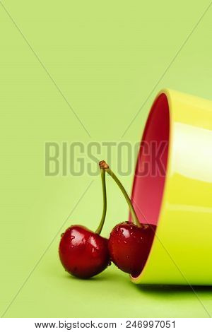 Fresh Cherries With Green Glass On Green Background