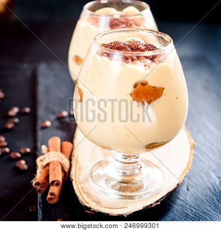 Traditional Italian Dessert Tiramisu In A Glass Jar On Dark Background