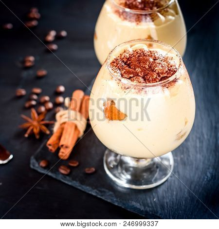 Traditional Italian Dessert Tiramisu In A Glass Jar On Dark Background