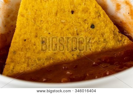 One Triangular Corn Chips With Spicy Taco Sauce In A Plate Macro Photo