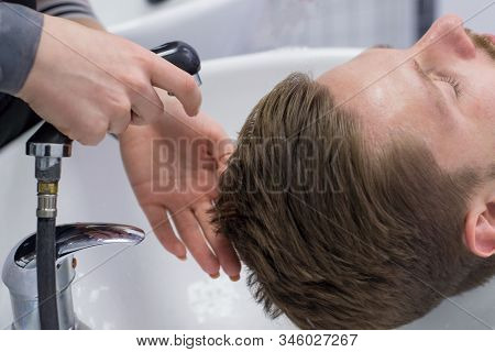 Close-up Of A Male Hair Care Master Washing A Mans Head In A Sink After Cutting His Hair