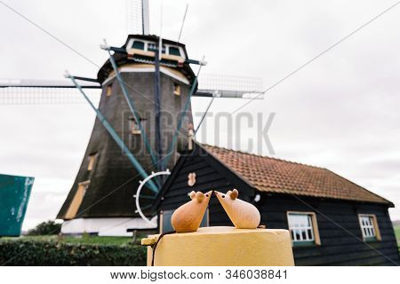 Two Wooden Mice Couple Sitting On A Metal Yellow Round Cylinder