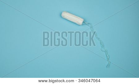 Medical Female Tampon On A Blue Background. Hygienic White Tampon For Women. Cotton Swab. Menstruati