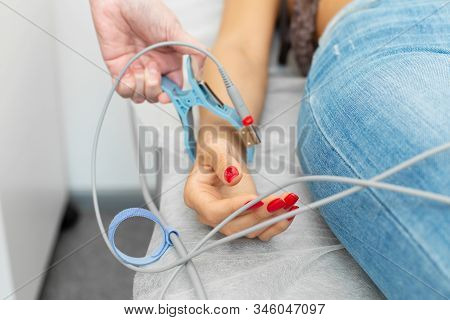 The Doctor Attaches The Electrodes Of The Ecg Pegs To The Patient Wrist.