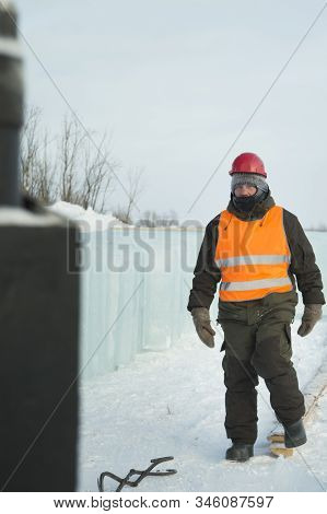 Slinger In An Orange Helmet Walks Down The Assembly Site