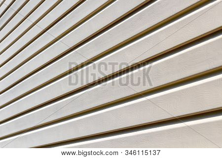 Part Of The Wall Of A Private House Covered With Plastic Beige Siding.