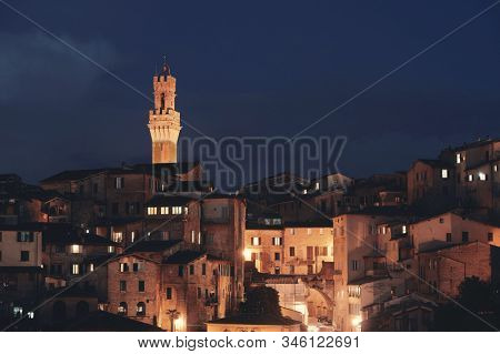 Medieval town Siena skyline view with Bell Tower and historic buildings in Italy at night