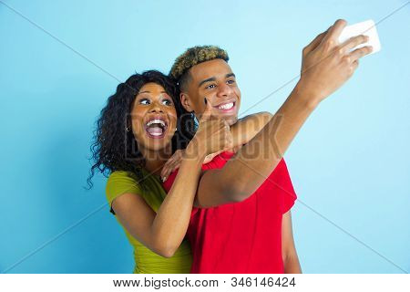 Taking Selfie Or Vlog Together. Young Emotional African-american Man And Woman In Colorful Clothes O