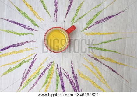 Top View With A Glass Of Red Water And Dehydrated Rice Grains On A Wooden Floor.