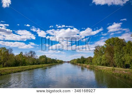 Lech Canal built for power generation and flood protection near Langweid am Lech, Swabia, Bavaria, Germany. Hydropower plant is seen in background